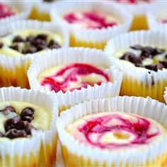 mini cheesecakes with chocolate chips and raspberry sauce in paper wrappers