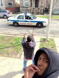 a police car parked on the side of a road next to a person eating food