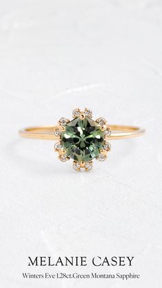 an engagement ring with a green stone in the center