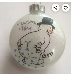 a white ornament with a snowflake maker on it's face