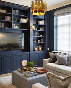 a living room with bookshelves, couch and coffee table in front of the window