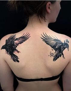 the back of a woman's shoulder with two black birds on it