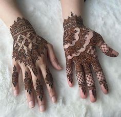 two hands with henna tattoos on them