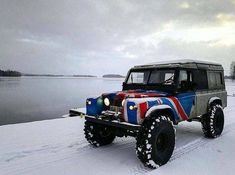 a jeep is painted in the colors of the united states flag driving on snow covered land