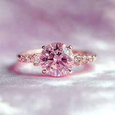 a pink diamond ring with three diamonds on it