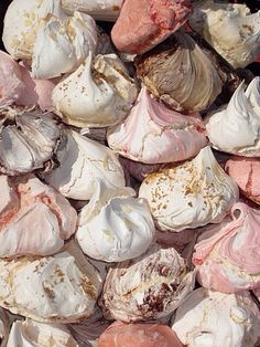 there are many different types of marshmallows on the table together, including pink and white