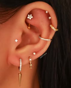 a woman wearing three different ear piercings and one has an arrow on the side