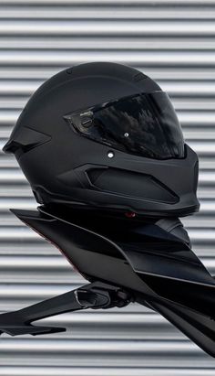 a motorcycle helmet on the back of it's stand up against a metal wall