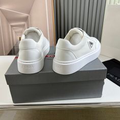 a pair of white shoes sitting on top of a box