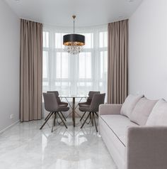 a living room filled with furniture and a chandelier hanging from the ceiling over a wooden floor