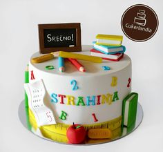 there is a cake with writing and school supplies on it