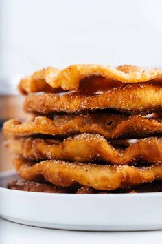 a stack of churros sitting on top of a white plate