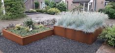 two large metal planters sitting on top of gravel