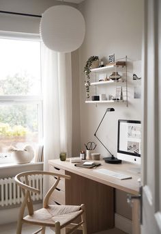 a desk with a computer and chair in front of a window, next to a radiator