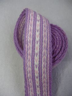 a purple and white striped yarn spool