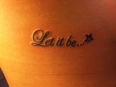 a tattoo saying let it be on the back of a woman's stomach,