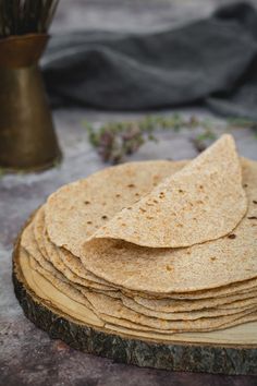 a stack of tortillas sitting on top of a wooden board