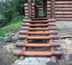 a wooden structure made out of logs in front of a log cabin with an open door