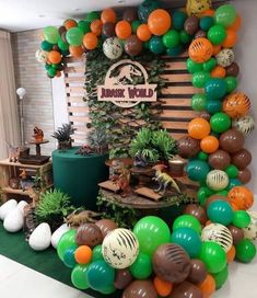 an assortment of balloons and plants on display at a zoo themed birthday party or baby shower