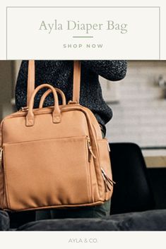 a woman carrying a tan purse with the words, ava diaper bag shop now