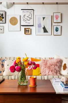 a living room filled with furniture and lots of pictures on the wall above it's coffee table