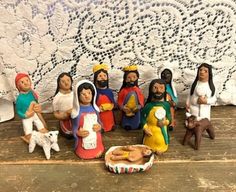 a group of figurines sitting on top of a wooden table next to a white wall