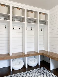 a white mud room filled with lots of shelves