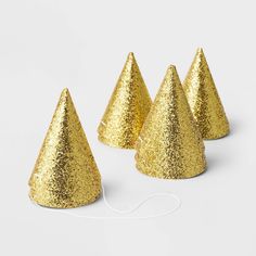 three gold glitter party hats on white background