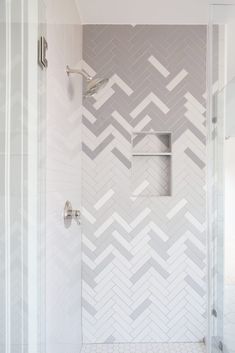 a bathroom with white and gray herringbone tile