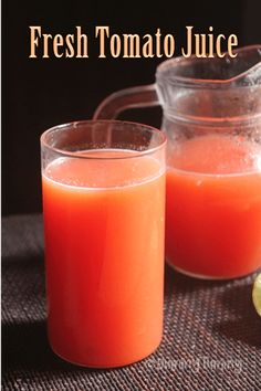 fresh tomato juice in glass and pitcher on table