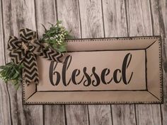 a wooden sign that says,'blessed'with a bow hanging on the front