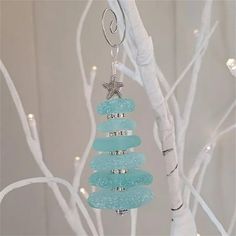 a glass ornament hanging from a tree with starfish on it's back