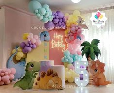 balloons are set up on the floor in front of a wall with dinosaurs and other decorations