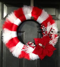 a red and white wreath on a door