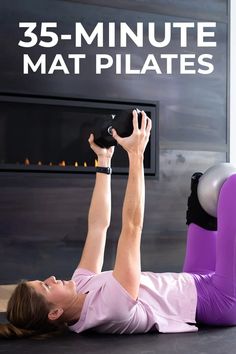 a woman laying on the floor with her legs up and holding a kettle in front of her