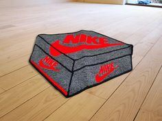 a rug with the word nike painted on it is laying on a wooden floor in front of a window