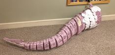 a paper mache shaped like a banana sitting on the floor next to a book shelf