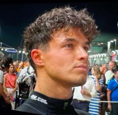 a man with curly hair standing in front of a crowd