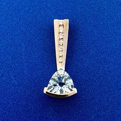 * Designer 14K White Gold Trillion Cut Blue Topaz Diamond Pendant * Length: 7/8" * Width: 3/8" * Trillion Cut Blue Topaz total carat weight: approximately 1.0 tcw * Seven round diamonds total carat: approximately .07 tcw * Weight: 1.8 tgw * Marked: 14K Makers Mark * Please see our listing for the matching ring * Chain is not included but can be purchased for an additional price * Condition: Great * G1376    Exported By ExportYourStore :) Ring Chain, Matching Ring, Swiss Blue Topaz, Matching Rings, Chain Ring, Makers Mark, Diamond Pendant, Blue Topaz, Round Diamonds