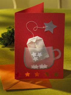 a red card with white stars on it and a tea bag in the shape of a mug