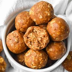 a bowl filled with muffins sitting on top of a white cloth next to some nuts