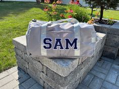 a duffel bag sitting on top of a stone wall