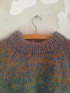 a sweater hanging on a wooden hanger