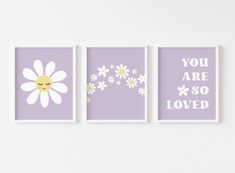 three purple and white wall art prints with daisies