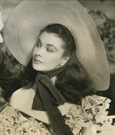 an old photo of a woman wearing a large hat