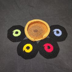 four crocheted coasters with colorful circles on them