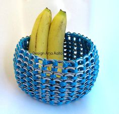 two bananas sitting in a blue and white basket on top of a table next to each other