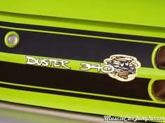 the front end of a green sports car with black stripes and white lettering on it