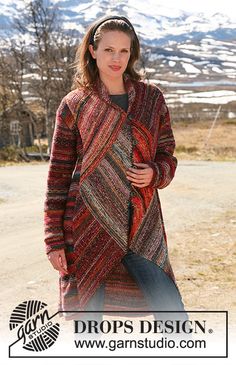 a woman standing in the middle of a road wearing a multicolored cardigan