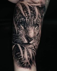 a black and white tattoo with a tiger on it's arm that has long hair